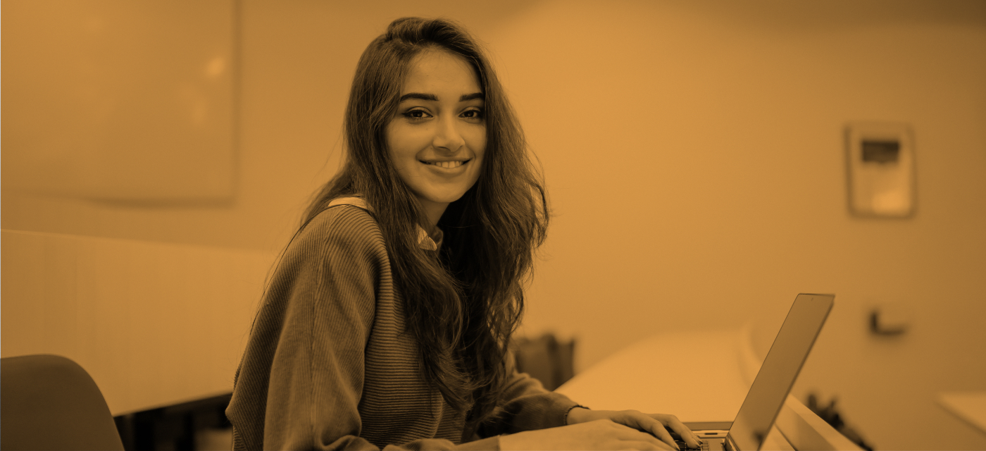 student smiling while working on computer